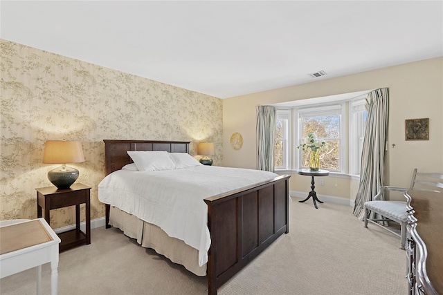 bedroom featuring visible vents, light carpet, baseboards, and wallpapered walls