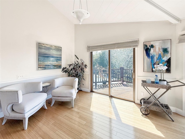 living area featuring vaulted ceiling, light wood-style floors, and baseboards