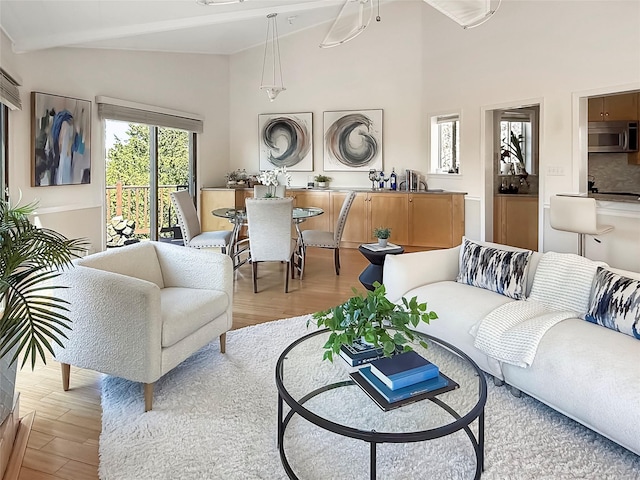 living room featuring light wood-style flooring and a towering ceiling