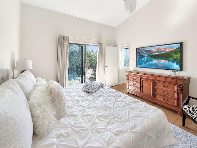 bedroom featuring light wood finished floors, access to outside, and lofted ceiling