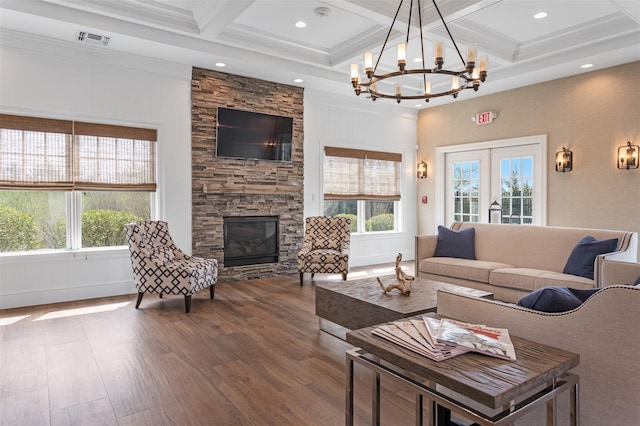 living room with a stone fireplace, wood finished floors, visible vents, french doors, and beam ceiling