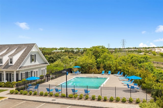 community pool with a patio and fence