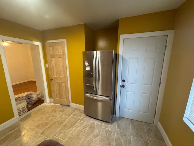 kitchen featuring baseboards and stainless steel refrigerator with ice dispenser