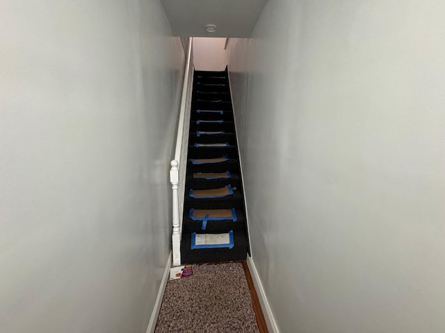 stairway featuring carpet floors and baseboards