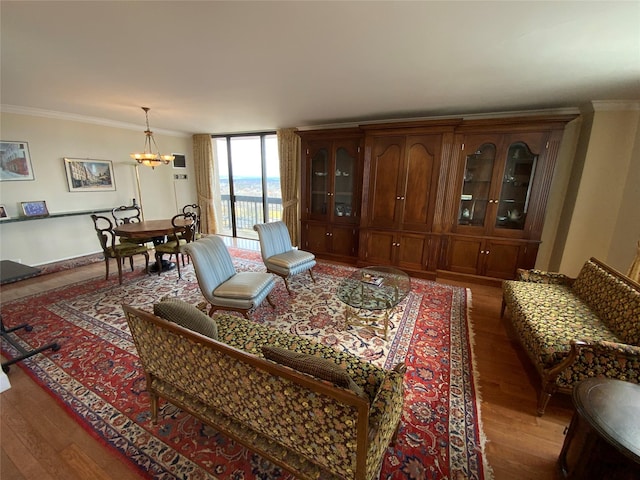 living room with light wood-style flooring, floor to ceiling windows, ornamental molding, and a notable chandelier