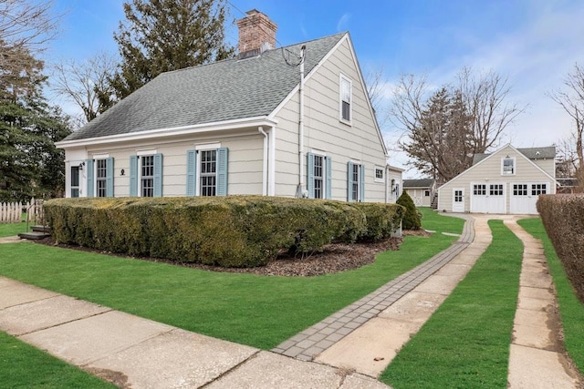 view of property exterior with a garage, a shingled roof, a chimney, a yard, and an outdoor structure