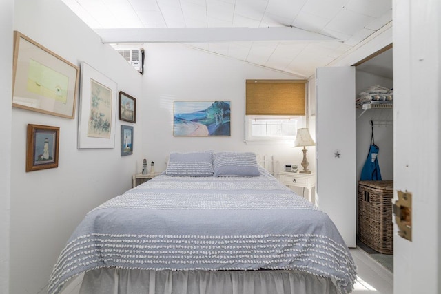 bedroom with a walk in closet, a closet, and lofted ceiling with beams