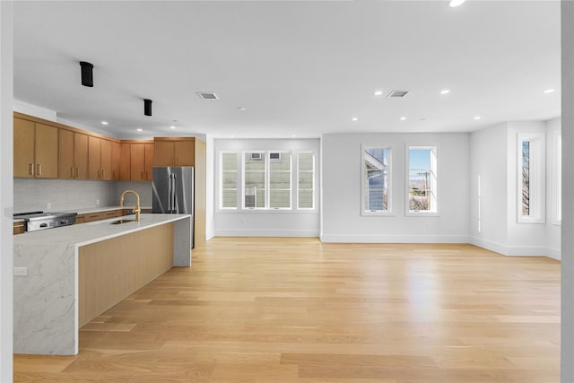 kitchen featuring light wood-style floors, visible vents, light countertops, and freestanding refrigerator