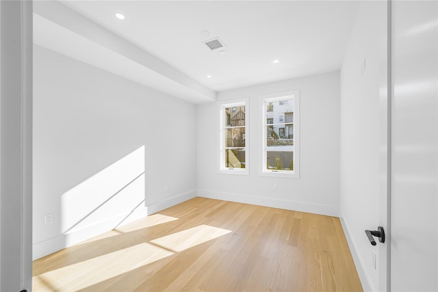 unfurnished room with recessed lighting, light wood-type flooring, visible vents, and baseboards