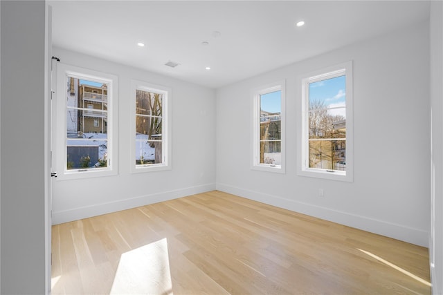 empty room with baseboards, wood finished floors, and recessed lighting