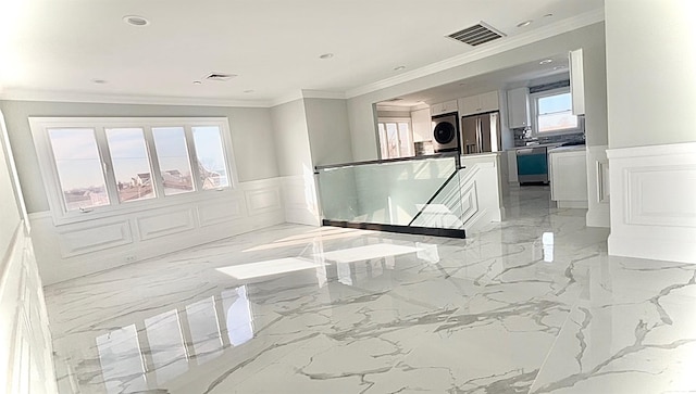 hall with marble finish floor, wainscoting, a decorative wall, and visible vents