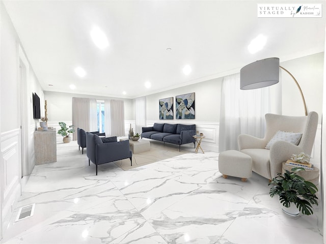 living area featuring wainscoting, ornamental molding, marble finish floor, a decorative wall, and recessed lighting