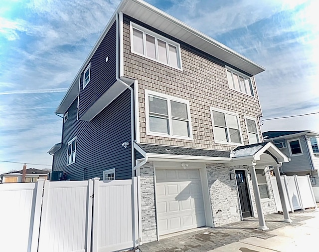 view of front of home with an attached garage and fence