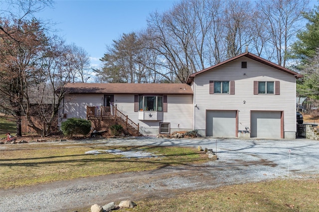 split level home featuring a front yard, driveway, stairway, and an attached garage