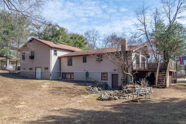 rear view of house with a chimney, a wooden deck, and stairs