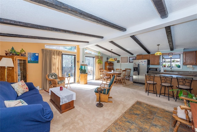 living room featuring light colored carpet, a textured ceiling, and lofted ceiling with beams