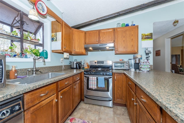 kitchen featuring brown cabinetry, stainless steel range with gas stovetop, a sink, a textured ceiling, and under cabinet range hood