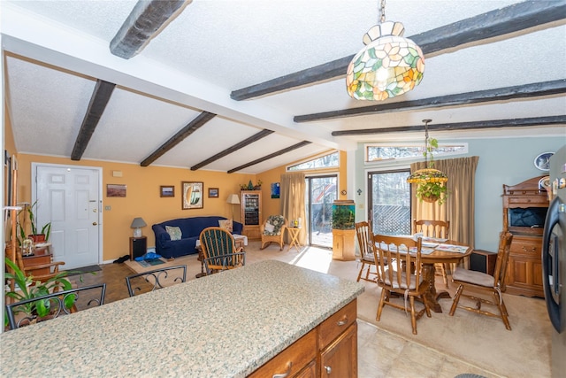 kitchen featuring brown cabinetry, open floor plan, vaulted ceiling with beams, and a textured ceiling