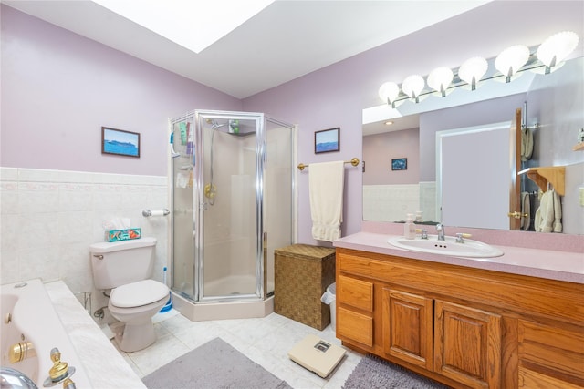 full bath featuring a skylight, tile walls, a shower stall, and toilet