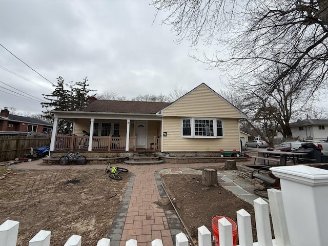 view of front of home with a porch and fence