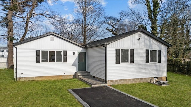 view of front of home with a front yard, fence, and entry steps