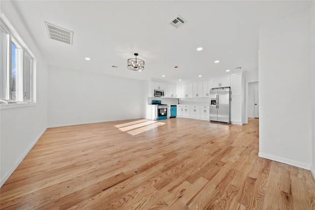 unfurnished living room with light wood-type flooring, baseboards, visible vents, and recessed lighting