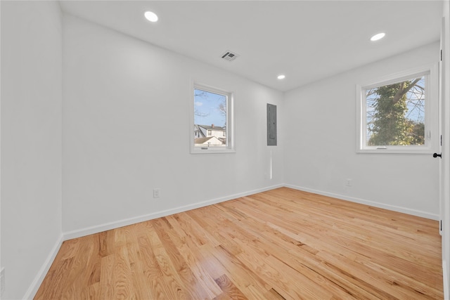 unfurnished room with recessed lighting, visible vents, wood finished floors, electric panel, and baseboards