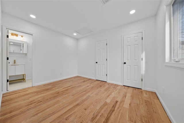 empty room featuring attic access, recessed lighting, baseboards, and light wood finished floors