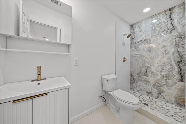 bathroom with visible vents, toilet, tile patterned flooring, tiled shower, and baseboards