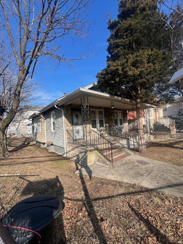 view of front of home featuring covered porch and brick siding