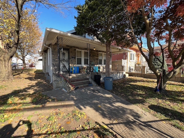 view of front of house with stone siding and a porch