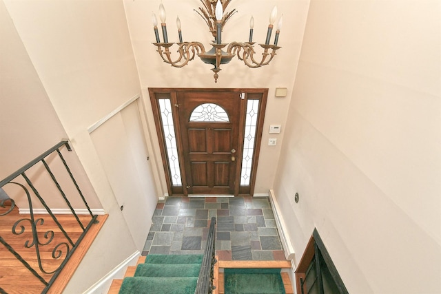 entrance foyer with stairway, baseboards, and a towering ceiling