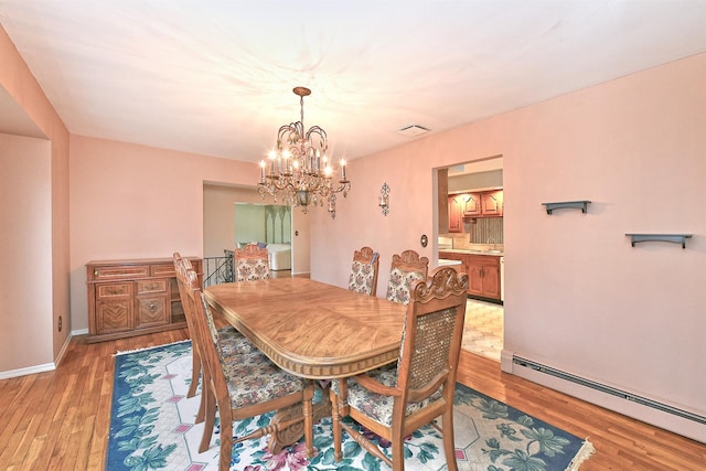 dining room featuring visible vents, a baseboard heating unit, baseboards, light wood-style floors, and a notable chandelier