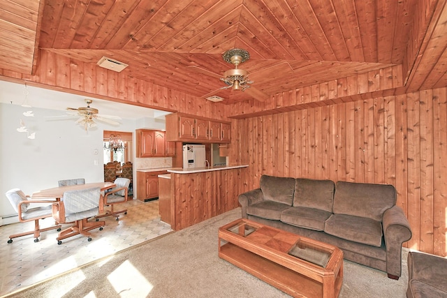 living area with wooden walls, a ceiling fan, visible vents, light carpet, and wooden ceiling