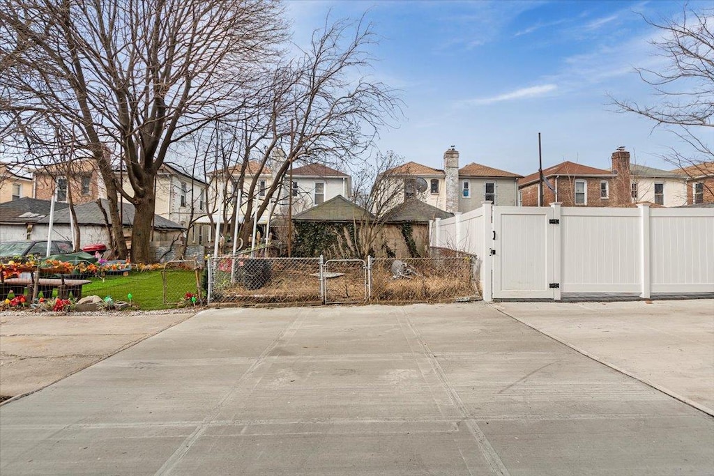 exterior space featuring a gate, fence, and a residential view