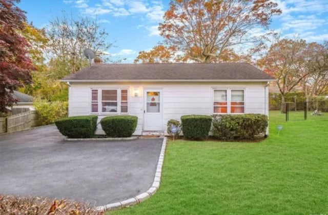 view of front of home with fence and a front lawn