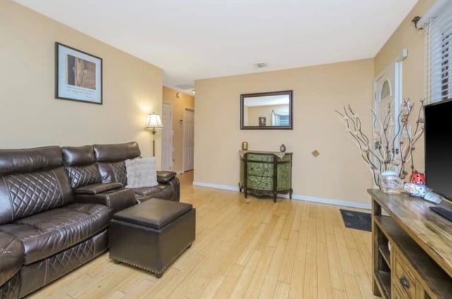 living room featuring light wood-type flooring and baseboards