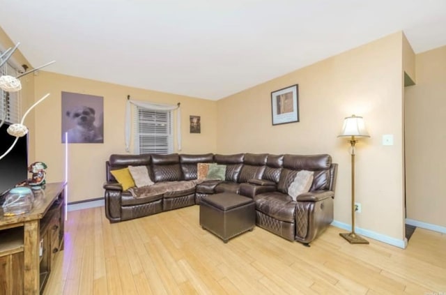 living area featuring baseboards and light wood finished floors