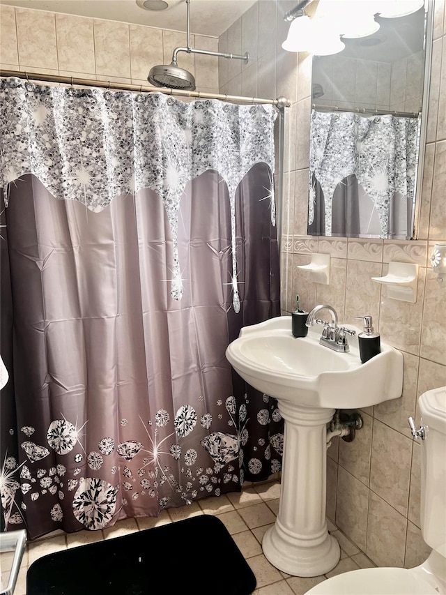 bathroom featuring decorative backsplash, toilet, tile patterned floors, curtained shower, and tile walls