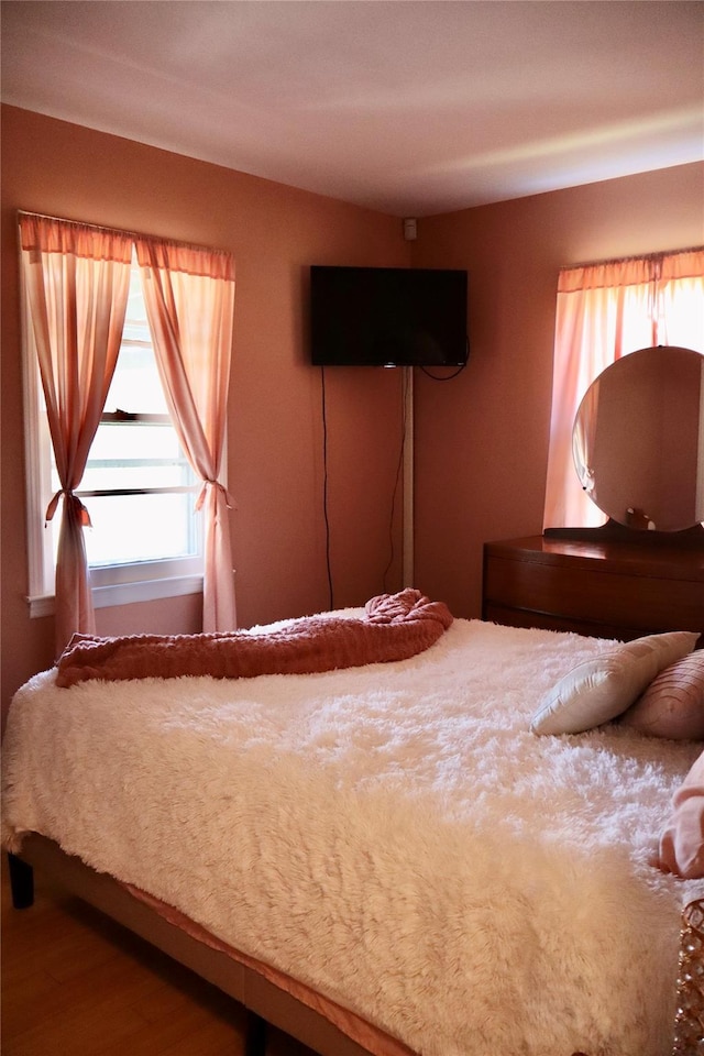 unfurnished bedroom featuring multiple windows and wood finished floors