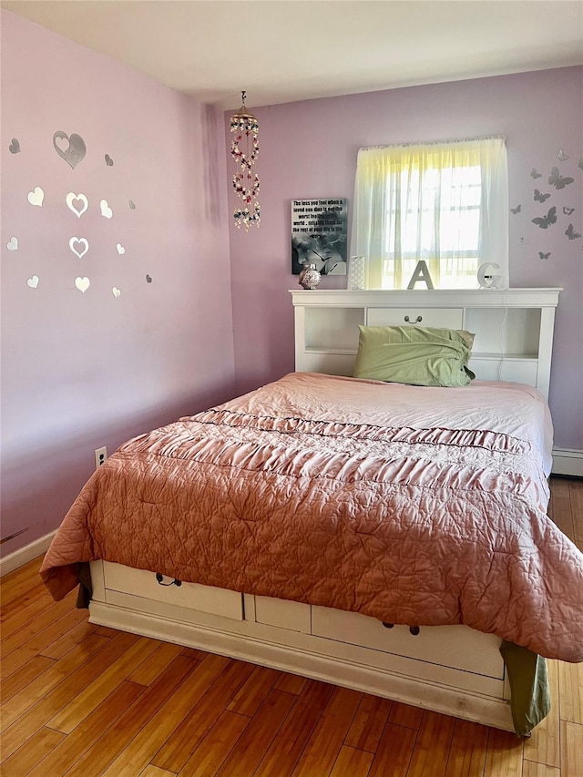 bedroom featuring hardwood / wood-style flooring and baseboards