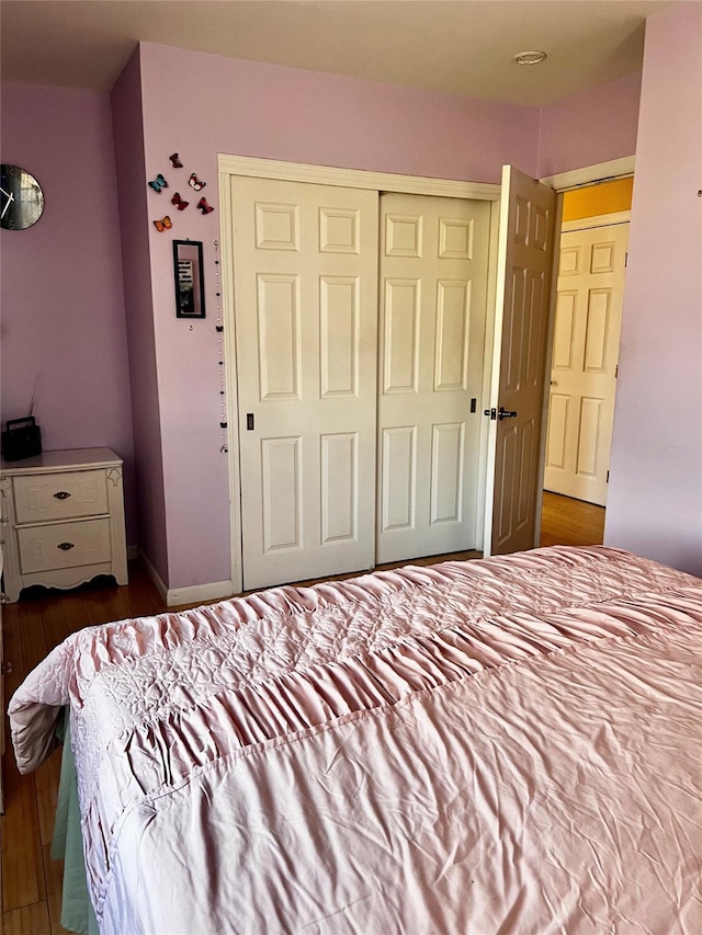 bedroom with a closet and dark wood finished floors