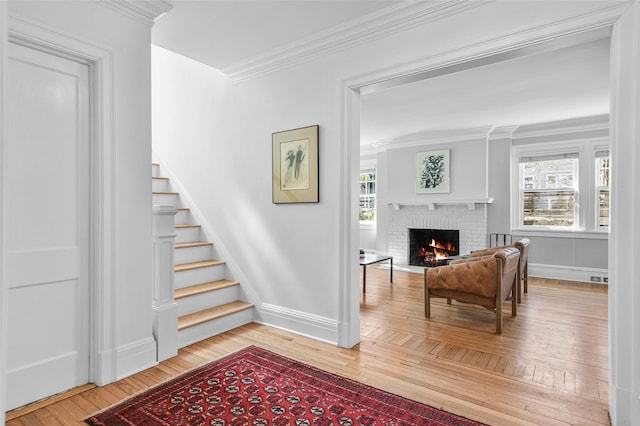 stairway featuring a wealth of natural light, a brick fireplace, hardwood / wood-style floors, and crown molding