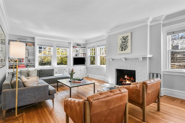 living room with built in features, a brick fireplace, wood-type flooring, and ornamental molding