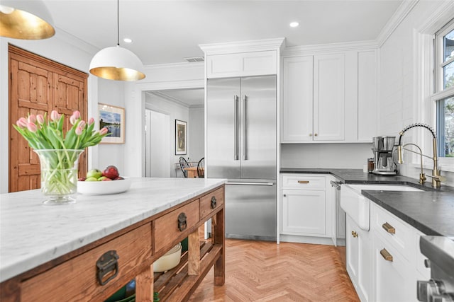 kitchen with white cabinetry, visible vents, and built in fridge