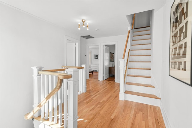 stairs with visible vents and wood finished floors