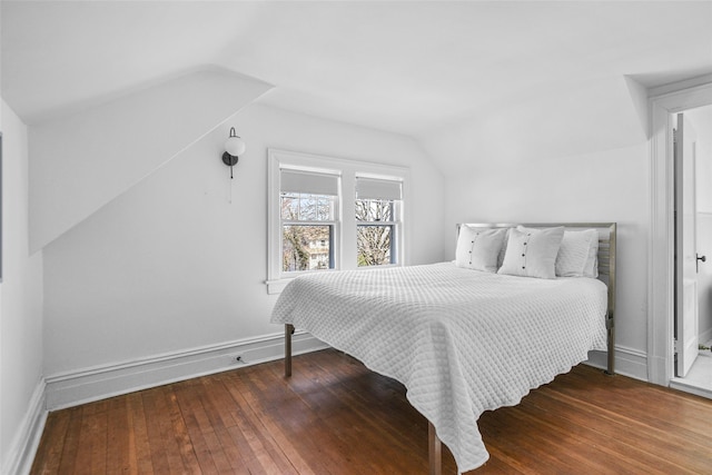 bedroom with baseboards, lofted ceiling, and hardwood / wood-style floors