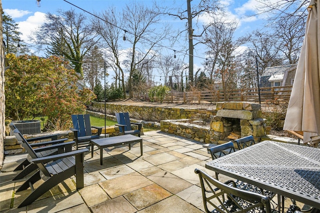 view of patio featuring central air condition unit, a fenced backyard, and outdoor dining space