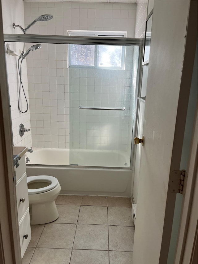 bathroom with shower / bath combination with glass door, toilet, and tile patterned floors