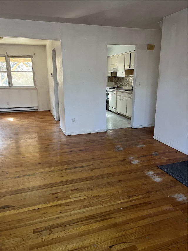 unfurnished living room with dark wood-style floors and a baseboard heating unit